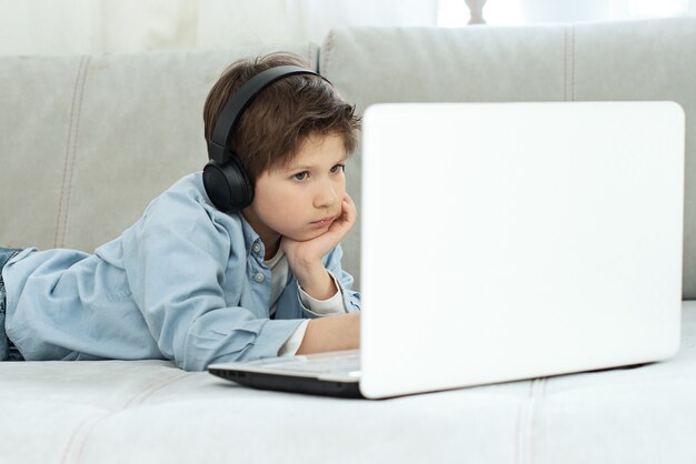 Distance learning during isolation during quarantine in coronovirus. Boy and laptop at home.