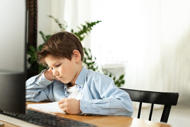 Distance learning during isolation during quarantine in coronovirus. Boy and laptop at home.