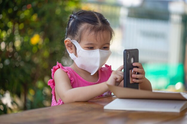 Distance learning online education. child in a mask to watch an online lesson.