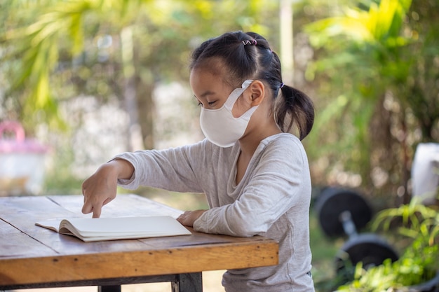 Distance learning online education. child in a mask to watch an online lesson.