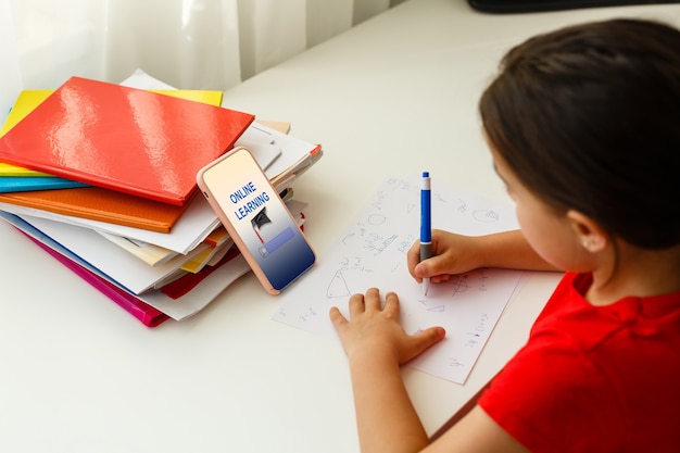 Distance learning online education, little girl writes formulas