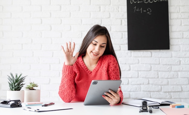 Apprendimento a distanza con la donna che insegna inglese online utilizzando il computer portatile