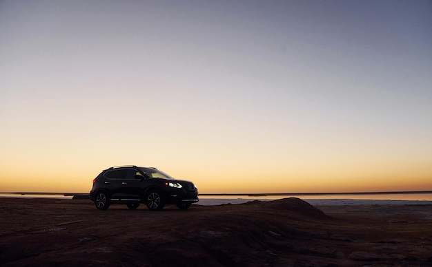 Distant view of modern black automobile that is on the coast