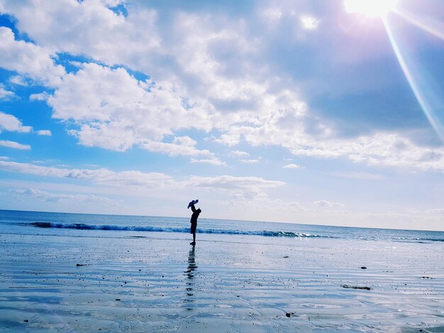 写真 浜辺で娘を抱いている父親の遠くの景色