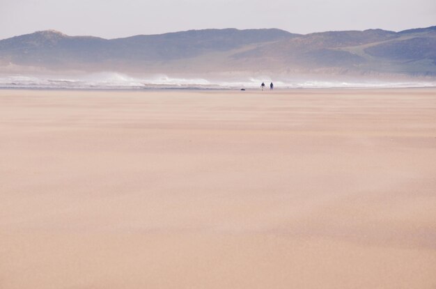 写真 岸に向かって急ぐ波の遠くの景色