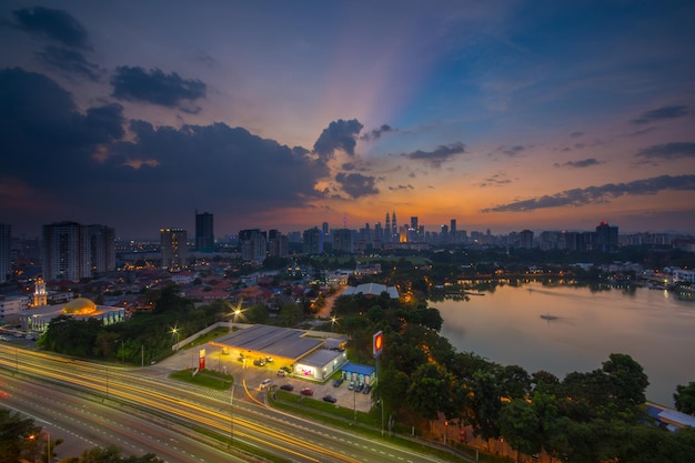 Photo distant view of petronas towers against sky during sunset in city