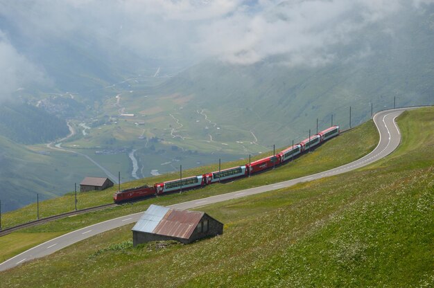 Foto vista lontana del treno con la catena montuosa sullo sfondo