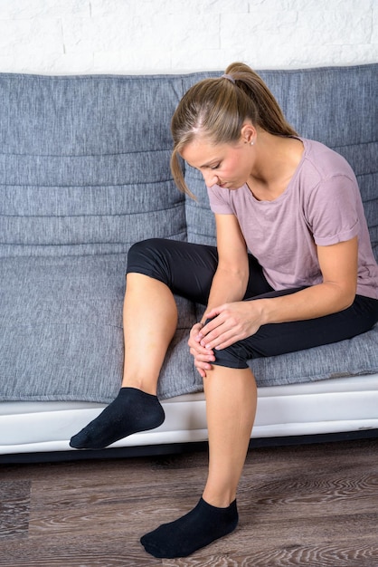 Photo distressed european student holds her knee