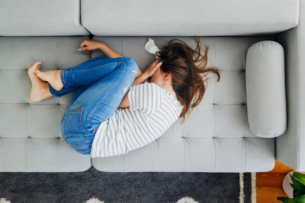 Distressed woman crying on sofa