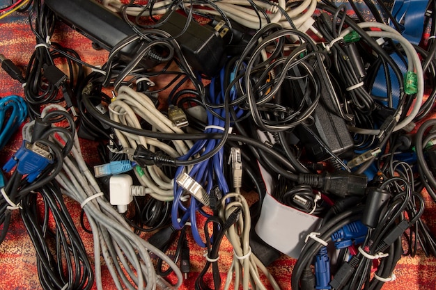 Вышедшие из употребления стопки старых компьютерных кабелей и устройств