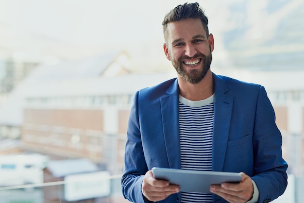 Dit handige apparaat heeft zoveel voor mijn bedrijf gedaan Portret van een jonge zakenman die in een kantoor op een digitale tablet werkt