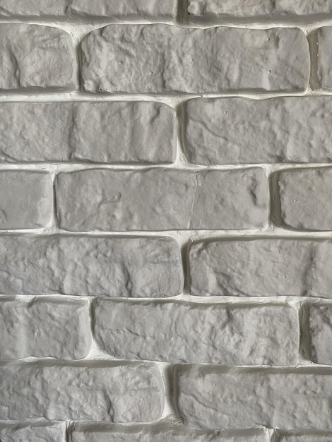 Dit is een zijaanzicht van een bakstenen muur de kleur is wit de naden tussen de bakstenen zijn wit