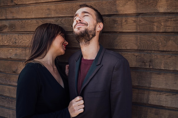 Dit is liefdesmeisje met een jongen die op een houten achtergrond poseert