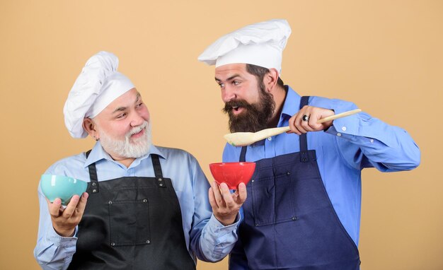 Dit is mijn favoriete eten Chef-kok mannen koken vrolijke mannen bereiden eten smaak eten culinair concept nieuw recept Perfecte smaak volwassen senior bebaarde mannen in de keuken professionele restaurantkok