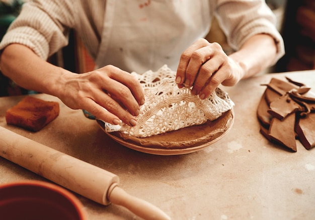 Dit ontwerp verkoopt als warme broodjes bijgesneden opname van een onherkenbare ambachtsman die in een pottenbakkerij werkt