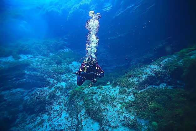 ダイバーは水泡の下で空気を吸い、ガスを放出し、水中の深さを風景します