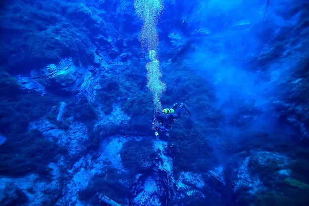 다이버는 물 거품 아래에서 공기를 호흡하고, 가스를 방출하고, 수중 깊이를 풍경화합니다.