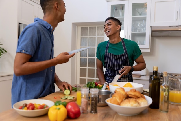 Divers homoseksueel mannelijk koppel brengt tijd door in de keuken, samen koken en glimlachen
