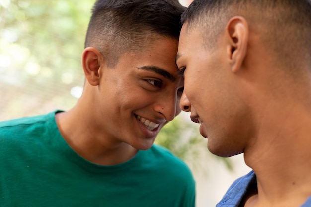 Divers homoseksueel mannelijk koppel kijkt naar elkaar en glimlacht