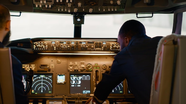 Divers team van kapitein en copiloot in cockpit vliegend vliegtuig, met behulp van de knoppen op het bedieningspaneel om op te stijgen. Dashboardcommando met radarkompasnavigatie en motor om vliegtuig te vliegen.