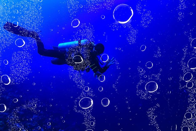 Photo divers underwater at depth in the blue sea background