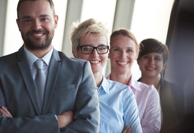 Foto diversi uomini d'affari raggruppano in piedi insieme come squadra negli interni moderni e luminosi dell'ufficio