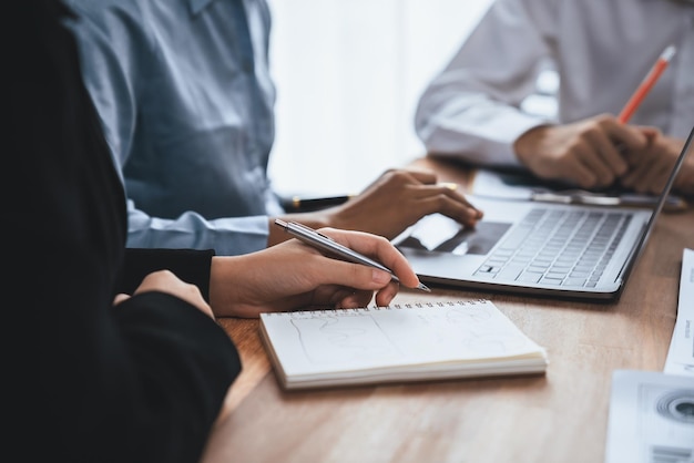 Diverse business people work together discuss in corporate office Professional teamwork discussing and pointing at laptop Modern multicultural office worker Concord
