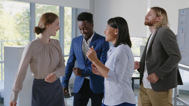 diverse business team dancing celebrating success in office