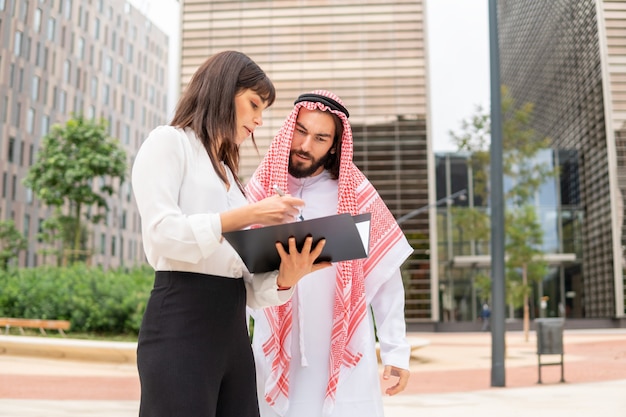 Diverse businesspeople reading papers together