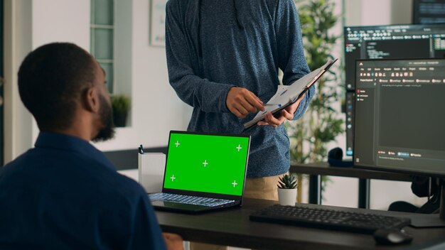 diverse coders working on code developing and using greenscreen in it agency office, programming database. looking at isolated mockup copyspace with chromakey display and template.