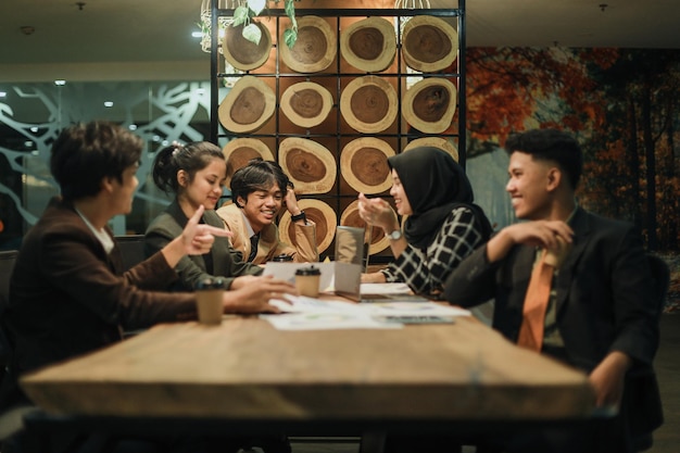 Diverse colleagues gather in boardroom brainstorming and discuss together