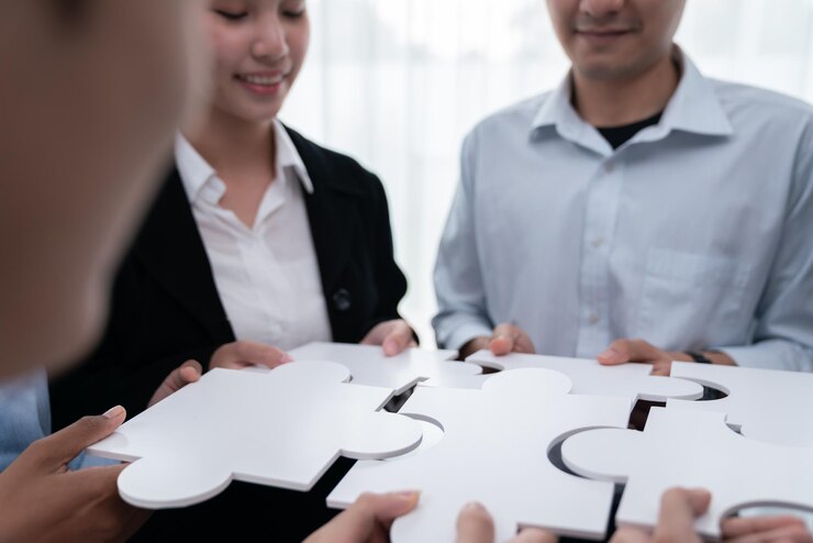 Photo コンコードのパズルのパーツをつなぐ様々な企業役員の労働者