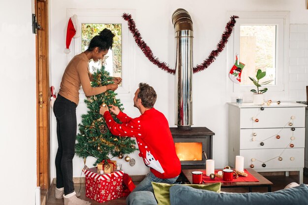 Diverse couple decorating Christmas tree