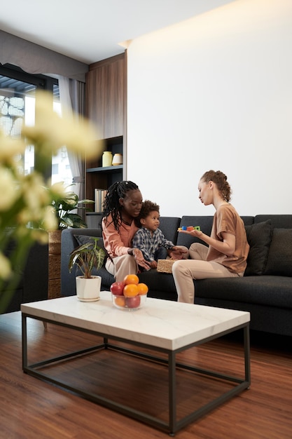 Diverse couple and their son spending time at home together and playing with toys