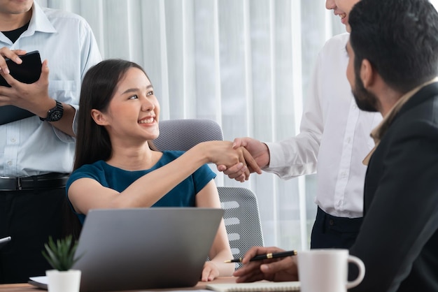 多様な同僚が企業の職場で握手とチームワークで成功を祝う オフィスで握手して連帯する幸せなプロフェッショナルの多文化チーム コンコード