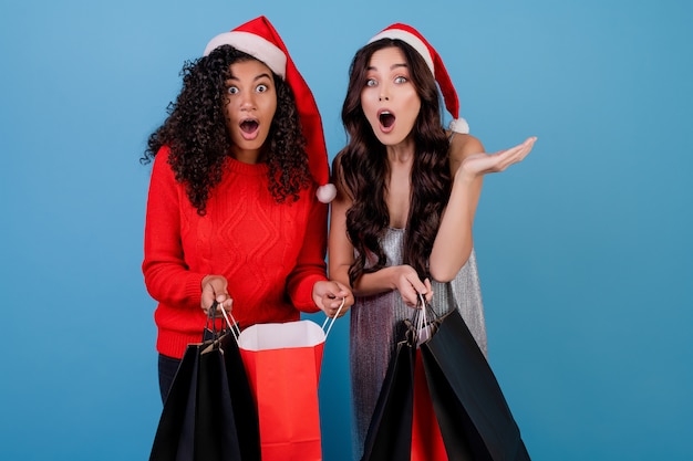 Diverse excited girls with black and red shopping bags