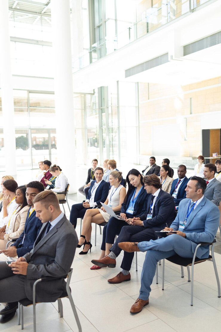 Photo diverse executives sat in conference room looking at laptop