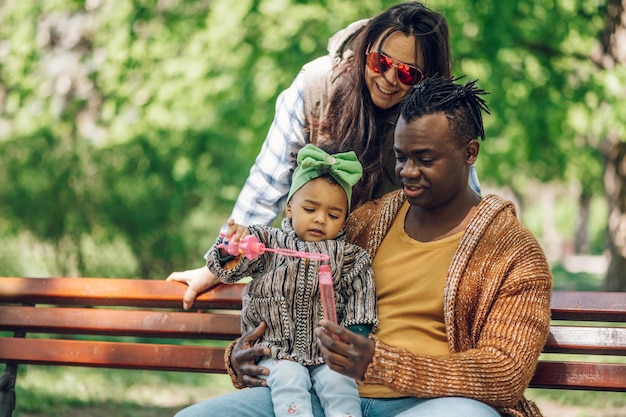 Diverse familie zeepbellen blazen in park