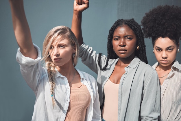 Photo diverse female activists or protesters fists up fighting for freedom and human rights a group of black lives matter supporters raising awareness for the political liberal movement and social justice