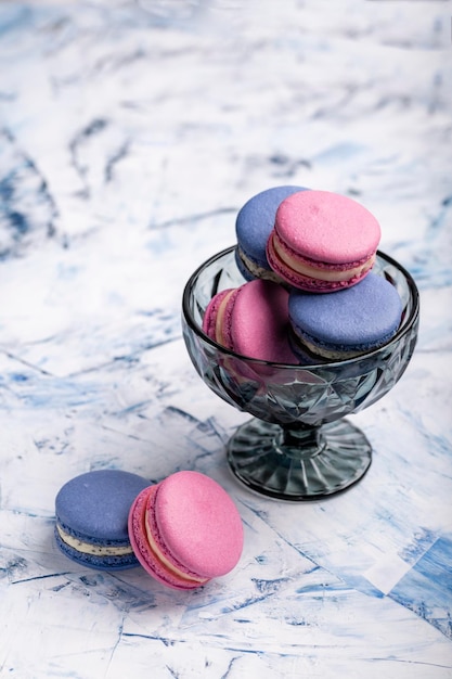 Diverse Franse amandelkoekjes in een glazen vaas op een lichte achtergrond