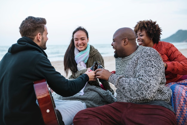 Diverse friends drinking beers at the beach