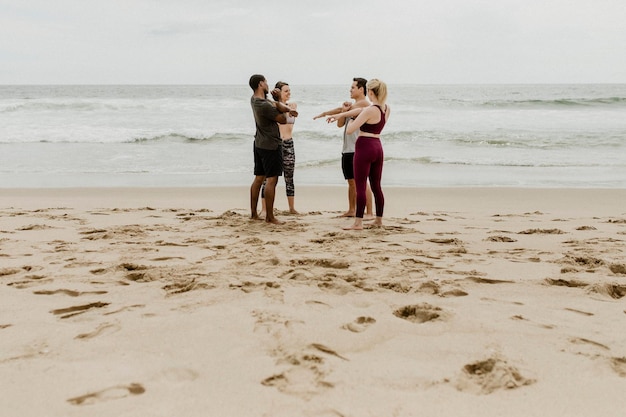 Diverse friends stretching at the beach