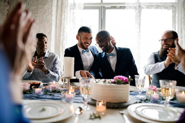 Diverse persone appena sposate coppia gay al tavolo della reception