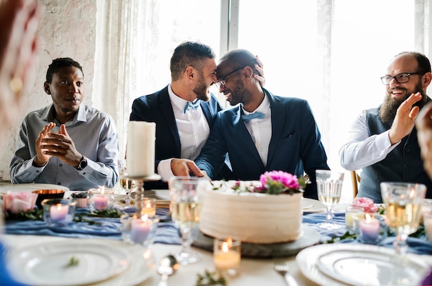 Diverse gay couple newlyweds at reception table