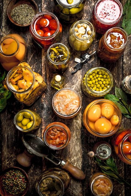 Foto diverse gekonfijte groenten en champignons met zeeman en kruiden. op een houten tafel.