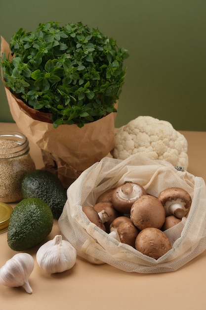 Diverse groenten pasta champignons en ontbijtgranen in herbruikbare stoffen eco tassen