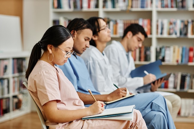 Diverse groep medici in rij zittend in publiek tijdens lezing of seminar