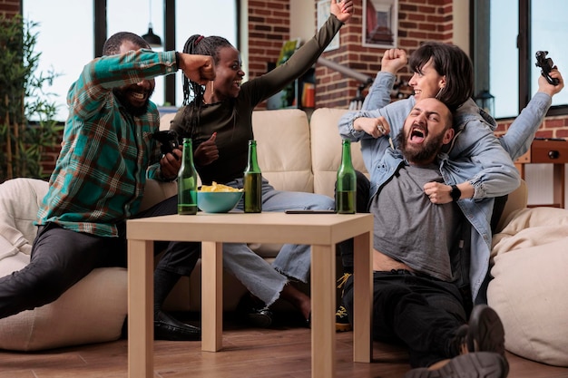 Diverse groep mensen die videogames viert, wint bij het verzamelen, samen plezier maken en genieten van de overwinning van de competitie. Je blij voelen over het winnen van gameplay op de televisieconsole.