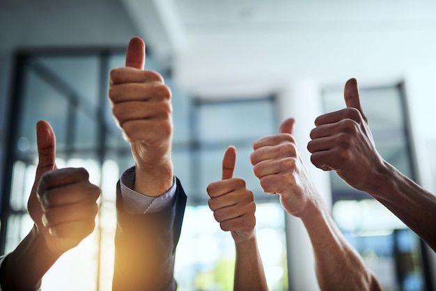 Foto diverse groep succesvolle zakenmensen goedkeuren en geven duimen omhoog voor tevredenheid en goed werk corporate team van vrolijke collega's die hun handen gebruiken om ja te zeggen met instemming