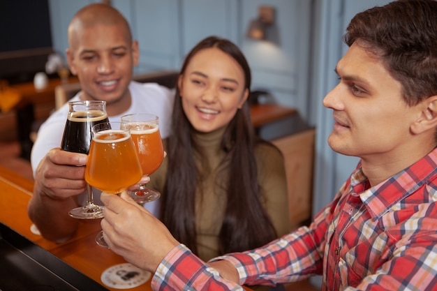 Diverse groep vrienden die bier drinken samen in de kroeg